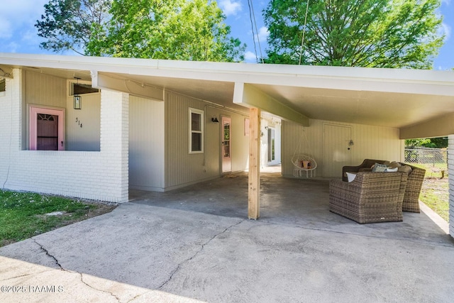 exterior space with an attached carport, driveway, and an outdoor hangout area