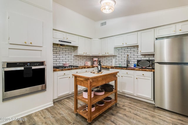 kitchen featuring dark countertops, white cabinetry, stainless steel appliances, and a sink