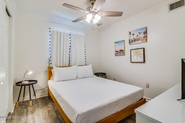 bedroom featuring baseboards, visible vents, a ceiling fan, dark wood-style flooring, and crown molding