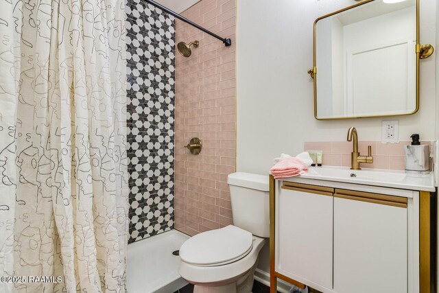 bathroom featuring a stall shower, vanity, and toilet