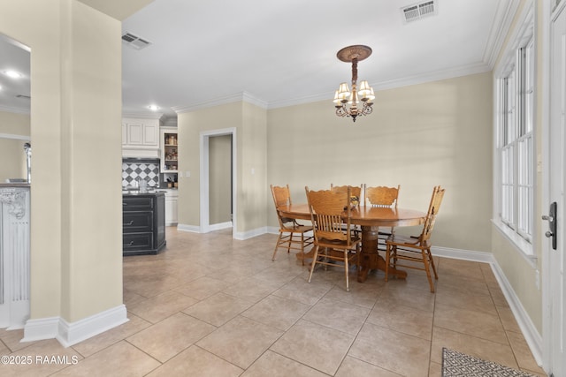 dining room with ornamental molding, a chandelier, and visible vents