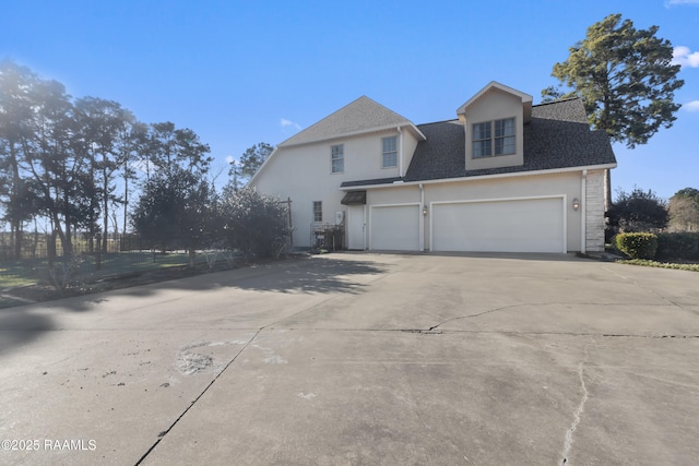 view of home's exterior featuring driveway, a shingled roof, a garage, and stucco siding