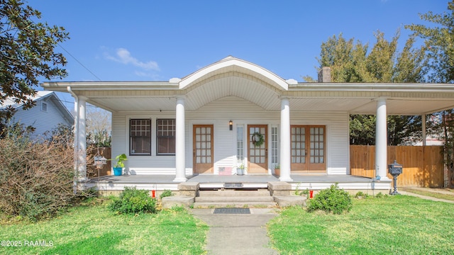 view of front of house featuring fence, a porch, and a front yard