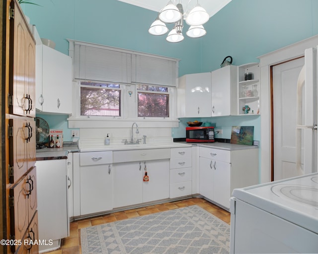 kitchen with open shelves, light countertops, freestanding refrigerator, white cabinetry, and range