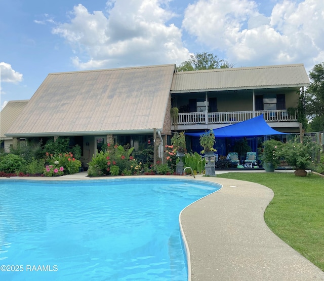 outdoor pool featuring a yard