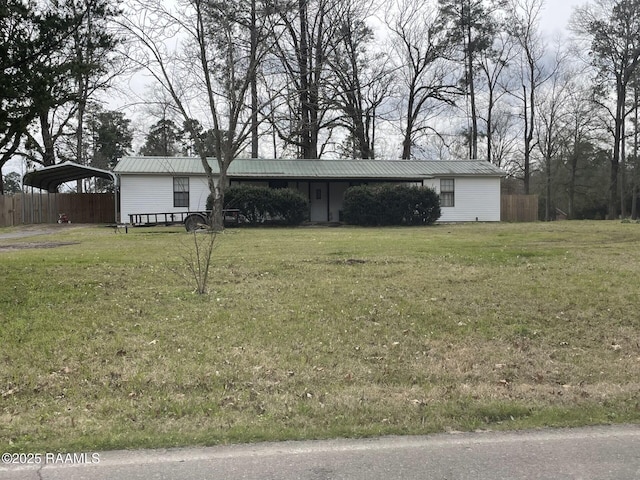 view of front facade featuring metal roof, a front lawn, fence, and a detached carport