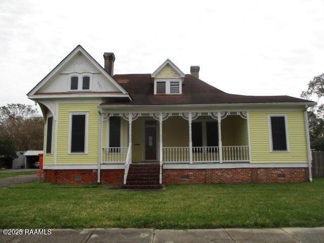 view of front of home featuring crawl space, covered porch, and a front lawn