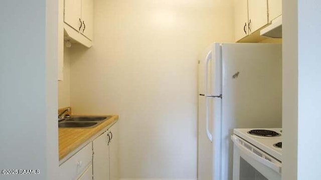 kitchen featuring light countertops, white appliances, white cabinets, and a sink