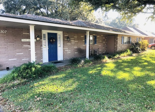 view of front of property with brick siding, covered porch, and a front yard