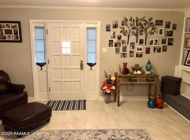 tiled foyer featuring baseboards and crown molding