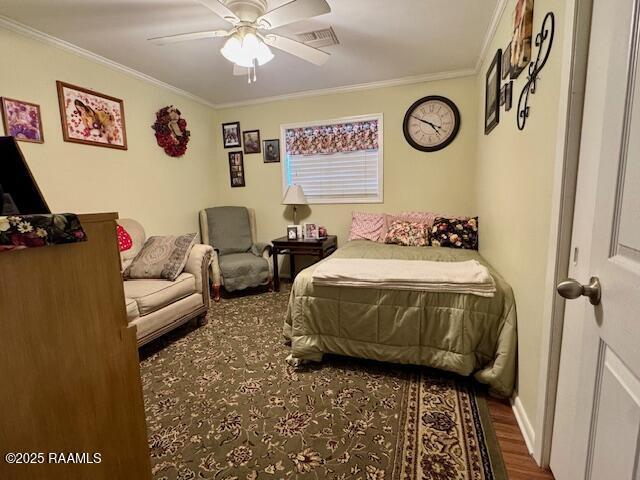 bedroom featuring ceiling fan, visible vents, crown molding, and wood finished floors