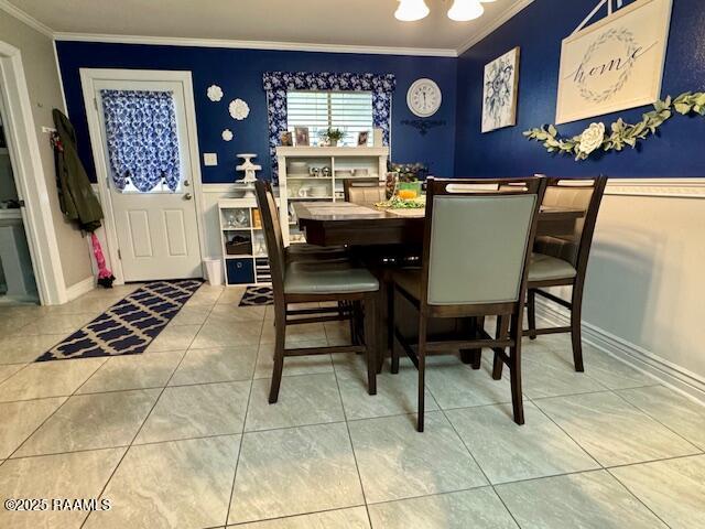 dining room with ornamental molding, tile patterned flooring, and a notable chandelier