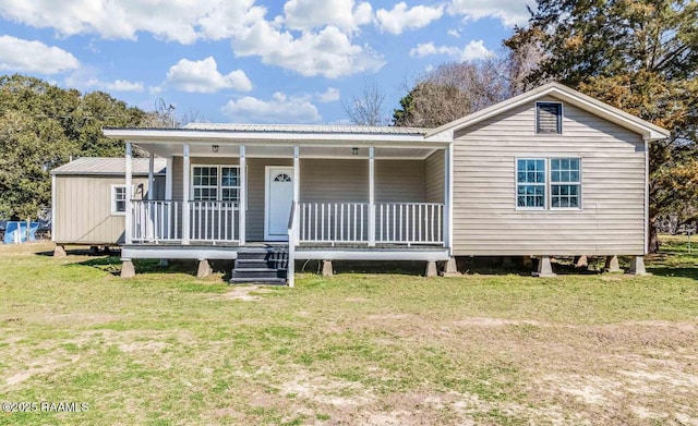 view of front of home featuring metal roof, a front lawn, and a porch