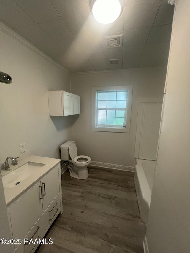 full bath with visible vents, toilet, vanity, wood finished floors, and baseboards