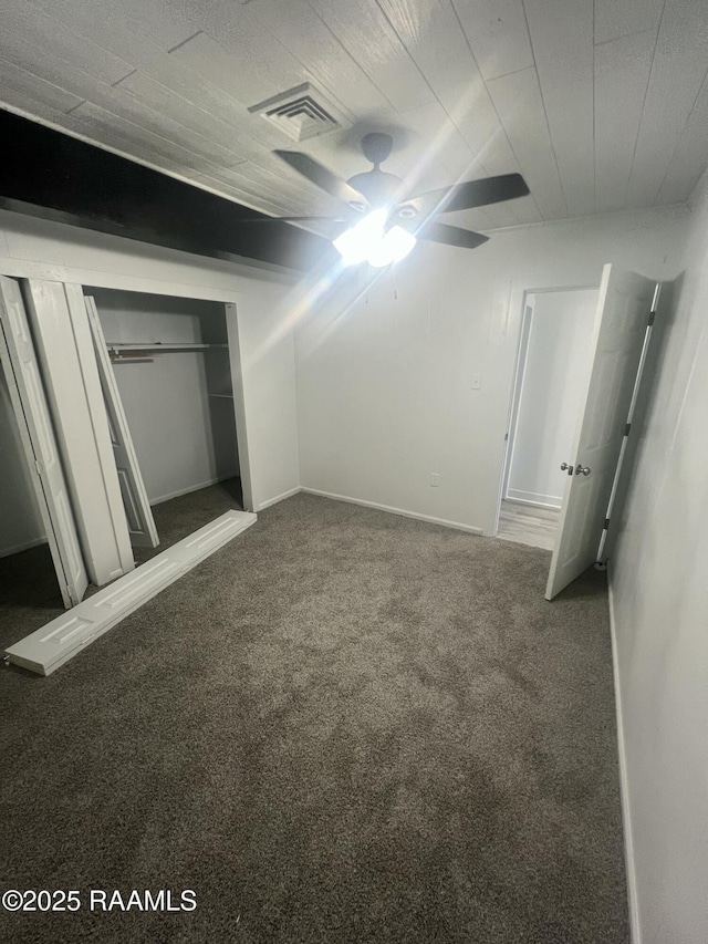 unfurnished bedroom with dark carpet and visible vents