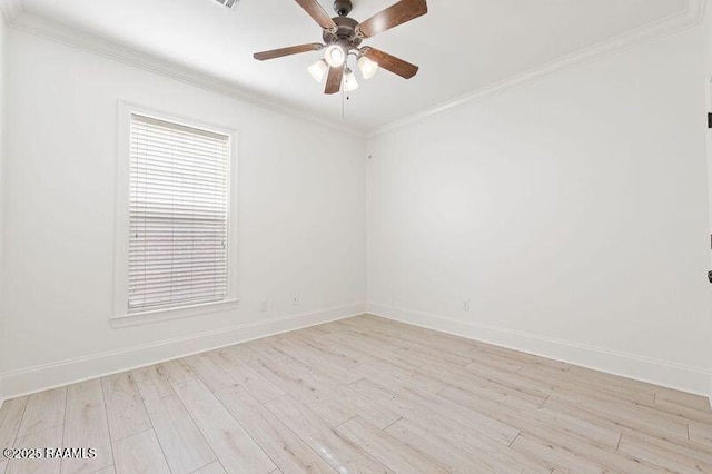 spare room with ornamental molding, light wood-style floors, baseboards, and ceiling fan