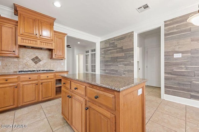 kitchen featuring light stone counters, crown molding, gas stovetop, light tile patterned floors, and visible vents