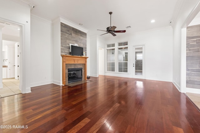 unfurnished living room with visible vents, ornamental molding, ceiling fan, and a tile fireplace