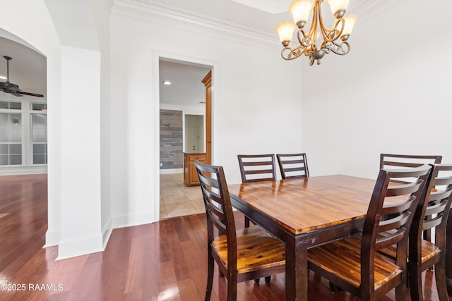 dining space with recessed lighting, ceiling fan with notable chandelier, wood finished floors, baseboards, and ornamental molding