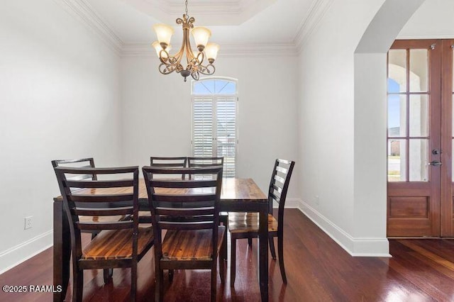 dining room featuring baseboards, arched walkways, dark wood-style flooring, and ornamental molding