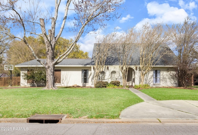 view of front of home featuring brick siding, a front yard, and fence