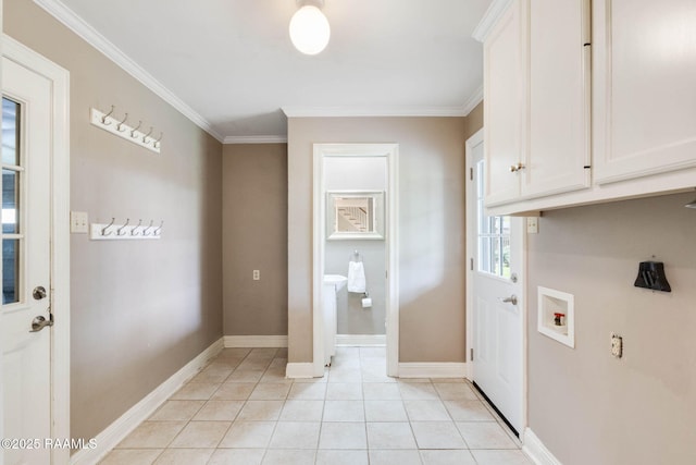 laundry area featuring washer hookup, crown molding, light tile patterned floors, and cabinet space