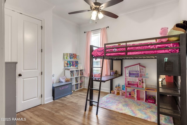 bedroom with baseboards, a ceiling fan, wood finished floors, and crown molding