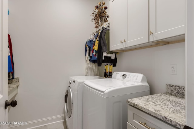 laundry room with cabinet space, washer and dryer, and baseboards