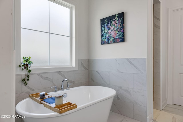 full bathroom with a soaking tub and marble finish floor