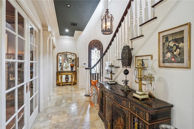 hall featuring french doors, crown molding, stone tile flooring, visible vents, and stairway