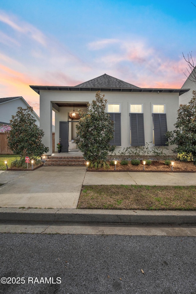 view of front of house with stucco siding and driveway