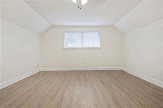 bonus room with vaulted ceiling, wood finished floors, and baseboards