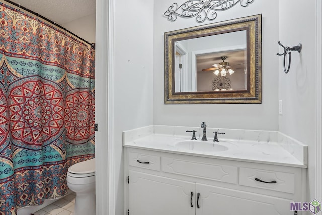 bathroom with toilet, ceiling fan, tile patterned flooring, a textured ceiling, and vanity