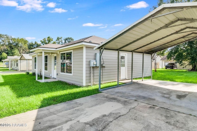 exterior space featuring a detached carport, driveway, and a front yard