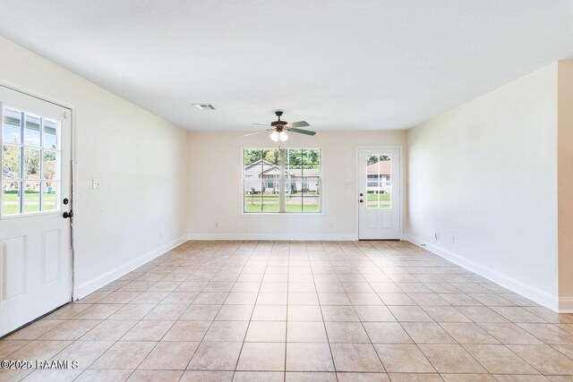 foyer entrance featuring light tile patterned floors, baseboards, visible vents, and a wealth of natural light