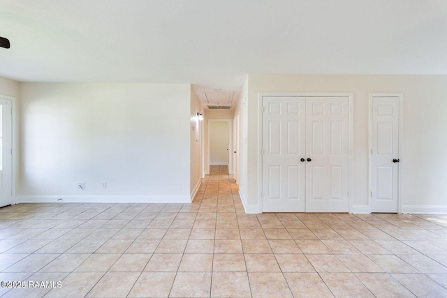 empty room with baseboards and light tile patterned flooring