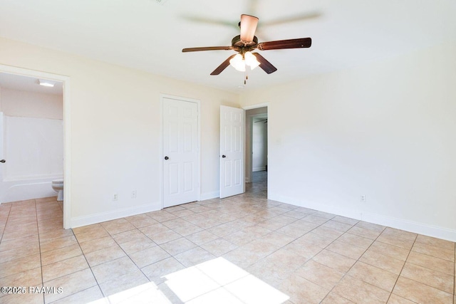 unfurnished room featuring a ceiling fan, baseboards, and light tile patterned floors