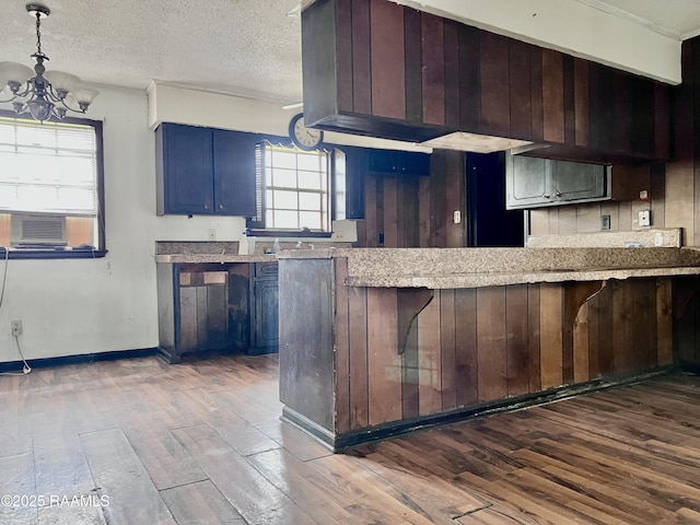 kitchen with a notable chandelier, light countertops, dark wood-type flooring, a textured ceiling, and blue cabinets