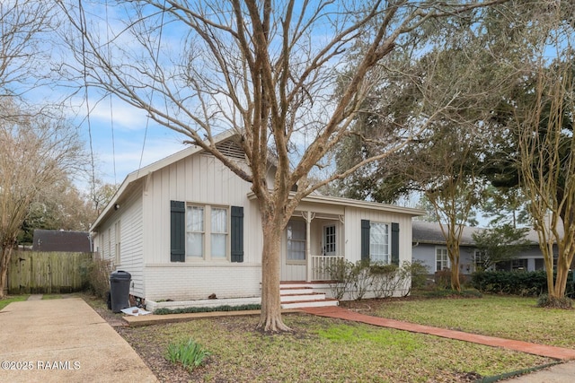 view of front of home featuring a front yard, covered porch, and brick siding