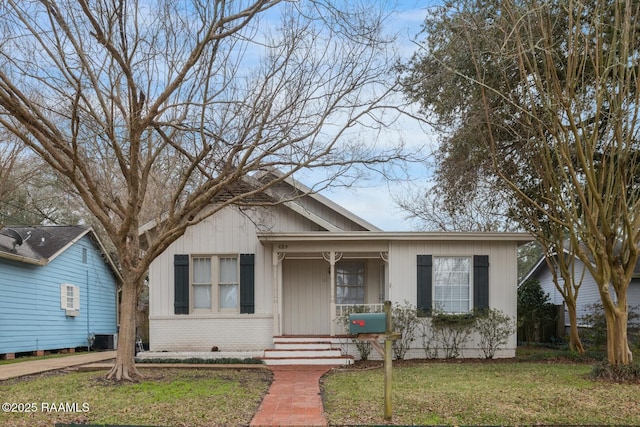 bungalow-style house with covered porch, brick siding, and a front lawn