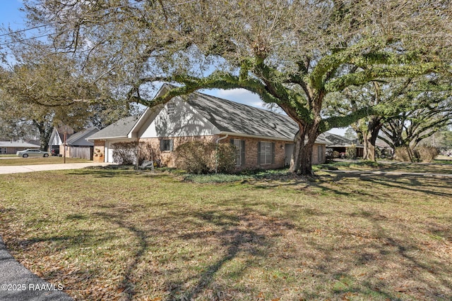 view of front facade featuring driveway, brick siding, a garage, and a front yard