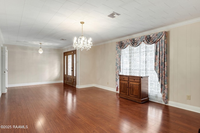 spare room with visible vents, dark wood finished floors, crown molding, and a chandelier