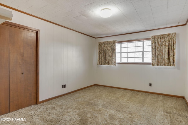 unfurnished bedroom featuring a closet, ornamental molding, and carpet flooring