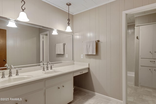 full bathroom with double vanity, ornamental molding, and a sink