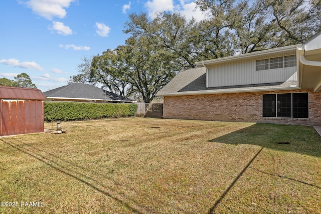 view of yard with a storage shed, an outdoor structure, and fence