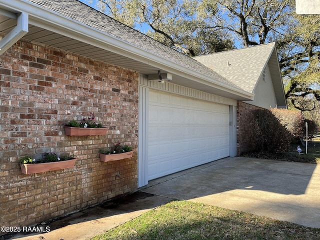 view of side of home featuring a garage, driveway, brick siding, and a shingled roof