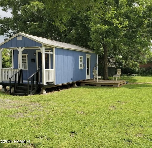 exterior space featuring a front yard, cooling unit, a porch, and metal roof