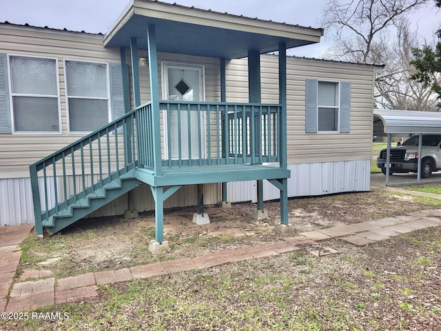 doorway to property with a porch and a detached carport