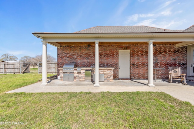 view of patio with area for grilling, an outdoor kitchen, and fence