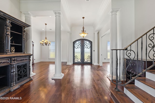 foyer entrance featuring french doors, stairs, ornate columns, and ornamental molding